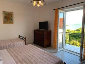 a bedroom with two beds and a television and a balcony at Green Apartment in Sreser