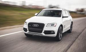 a white audi car driving down a road at Albanian Car Hire in Rinas