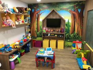 a play room with toys and a mural of a forest at Hotel Geranium in Balneário Camboriú