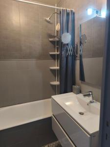 W łazience znajduje się umywalka oraz prysznic z wanną. w obiekcie Location vacances Barcelonette w mieście Barcelonnette