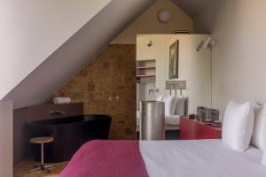 a bedroom with a bed and a bathroom with a tub at Hotel Pilar in Antwerp