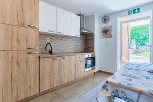 a kitchen with wooden cabinets and a table at Anabella in Martinšćica