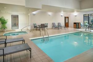 a pool in a hotel room with tables and chairs at Fairfield by Marriott Inn & Suites Asheville Outlets in Asheville