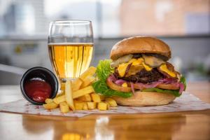 a hamburger and french fries and a glass of beer at Hostal R10 in Bogotá +73 photos