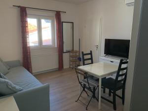 a living room with a table and a television at Vinka Apartment in Sreser