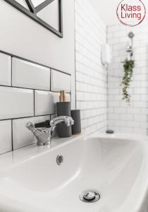 a white sink with a faucet in a bathroom at Garturk Apartment by Klass Living Coatbridge in Coatbridge +28 photos