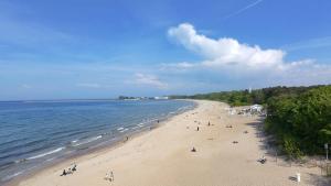 a group of people on a beach near the water at Nadmorska Miła in Gdańsk