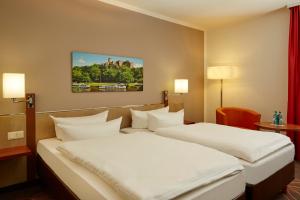 a hotel room with two beds in a room at Sunday Hotel Leipzig-Halle in Landsberg OT Peißen +18 photos