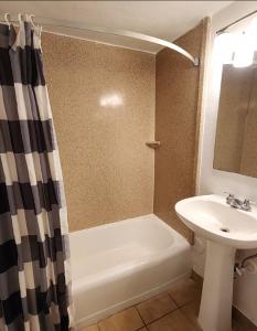 Un baño con lavabo, bañera e inodoro. en Welcome Inn and Suites, en Saint Johns
