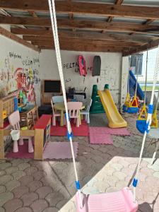 a play room with a swing and a playground at Villa Anna in Hanioti