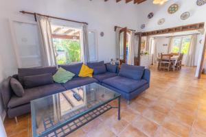 a living room with a blue couch and a glass table at Charming villa with A/C and WIFI in Pollença