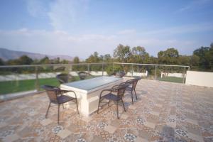 a patio with a table and chairs on a roof at 4 BHK Lavish villa in Bhose in Mahabaleshwar
