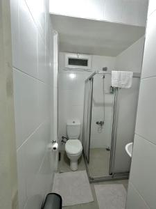 a white bathroom with a toilet and a shower at Hostel Nelly in Istanbul