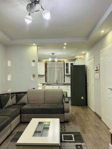 a living room with a couch and a table at Korca Apartment in Korçë +7 photos