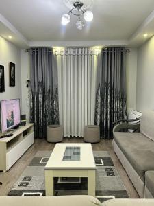 a living room with a couch and a table at Korca Apartment in Korçë