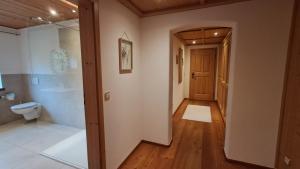 a hallway leading to a bathroom with a toilet at Ödmühle - Chiemgau Karte in Inzell