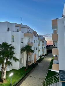 a large white building with palm trees in front of it at Achakar Hill in Tangier