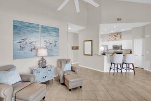 a living room with a couch and chairs and a kitchen at 305 West in Gulf Highlands