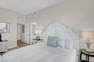 a white bedroom with a large white bed with blue pillows at 305 West in Gulf Highlands +33 photos