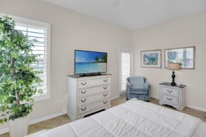a bedroom with a bed and a tv on a dresser at 305 West in Gulf Highlands