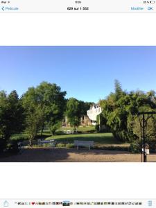 a picture of a park with a bench and a house at La Maison d'Ambre in Saint-Laurent-en-Gâtines