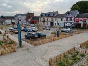 a town with cars parked in a parking lot at Gite 6 à 8 personnes in Gamaches