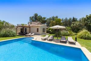 a swimming pool with chairs and a house at Charming villa with A/C and WIFI in Pollença