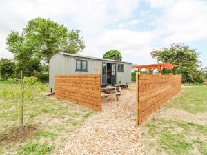 a tiny house with a fence and a shed at Woodpecker in Cambridge
