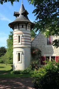ein Gebäude mit einem Turm vor einem Haus in der Unterkunft Maison d'Hôtes La Chouanniere in Brion