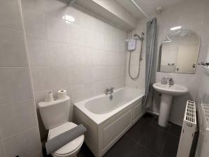 a white bathroom with a toilet and a sink at Chelmsford 5 Bedroom Large House with Garden & Parking in Chelmsford