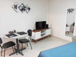 a bedroom with a desk and a tv and a bed at Studio 1811 Campinas SP in Campinas