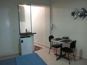 a room with a table and chairs and a small refrigerator at Studio 1811 Campinas SP in Campinas
