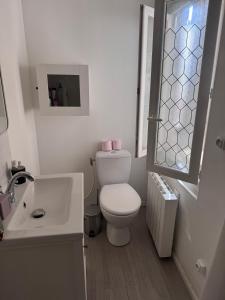 a white bathroom with a toilet and a sink at Le Farges-Chambre en colocation-Appartement partagé à 3min de La Gare ST Roch-LaConciergerieByNina in Montpellier