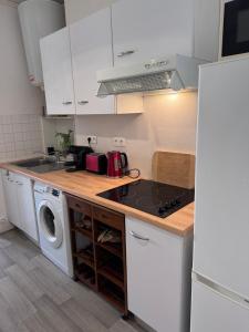 a kitchen with a stove top oven next to a washing machine at Le Farges-Chambre en colocation-Appartement partagé à 3min de La Gare ST Roch-LaConciergerieByNina in Montpellier +2 photos