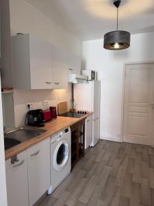a kitchen with a washing machine and a washer at Le Farges-Chambre en colocation-Appartement partagé à 3min de La Gare ST Roch-LaConciergerieByNina in Montpellier