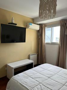 a bedroom with a bed and a tv on the wall at Galeria Estrada in Villa Carlos Paz