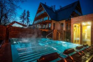 uma casa com piscina em frente a uma casa em Apart-Center Pod Gwiazdami SPA em Zakopane