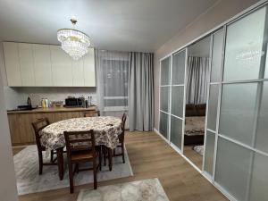 a kitchen and dining room with a table and chairs at Rams in Almaty