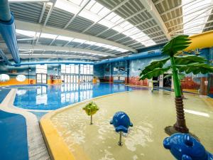 a swimming pool with a palm tree in the middle at Starlight Skylight - Billing Aquadrome in Northampton