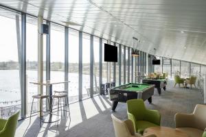 a room with a pool table and chairs and windows at Starlight Skylight - Billing Aquadrome in Northampton