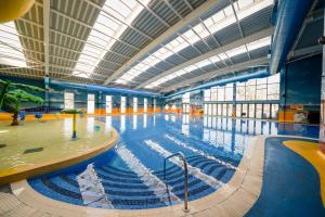 a large indoor swimming pool with a large ceiling at Starlight Skylight - Billing Aquadrome in Northampton +38 photos