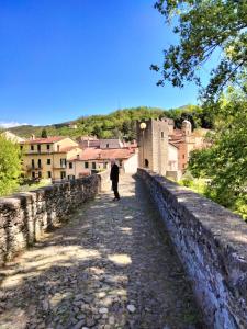 a person standing on a stone wall looking at a city at Tuscany, Pontremoli, Italy Swallows Court Lovely home sleeps 2 to 4 people in Pontremoli