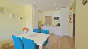 een keuken en eetkamer met een tafel en blauwe stoelen bij Praia Eulália with pool and 5 minutes from the beach in Albufeira