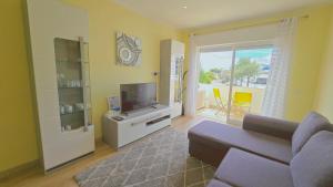 een woonkamer met een bank en een flatscreen-tv bij Praia Eulália with pool and 5 minutes from the beach in Albufeira