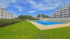 een zwembad in het midden van een tuin met gebouwen bij Praia Eulália with pool and 5 minutes from the beach in Albufeira
