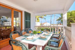 Una mesa de comedor blanca y sillas en un balcón con una mesa y sillas de escritorio. en Villa Gatzara by Villa Plus, en Cala Blanca