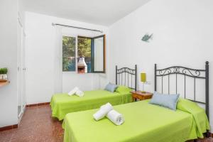 Dos camas en una habitación con sábanas verdes. en Villa Gatzara by Villa Plus, en Cala Blanca 33 fotos más