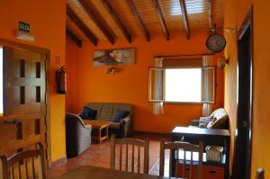 a living room with orange walls and a table and chairs at El Balcón de Onís in La Robellada de Onis
