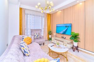 a living room with a couch and a tv at Leshwa House 1 in Nairobi