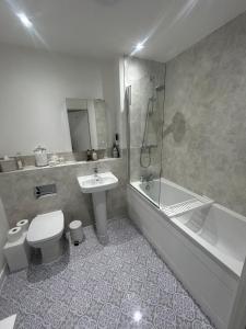 a bathroom with a toilet and a sink and a bath tub at Beautiful apartment in Chichester +11 photos